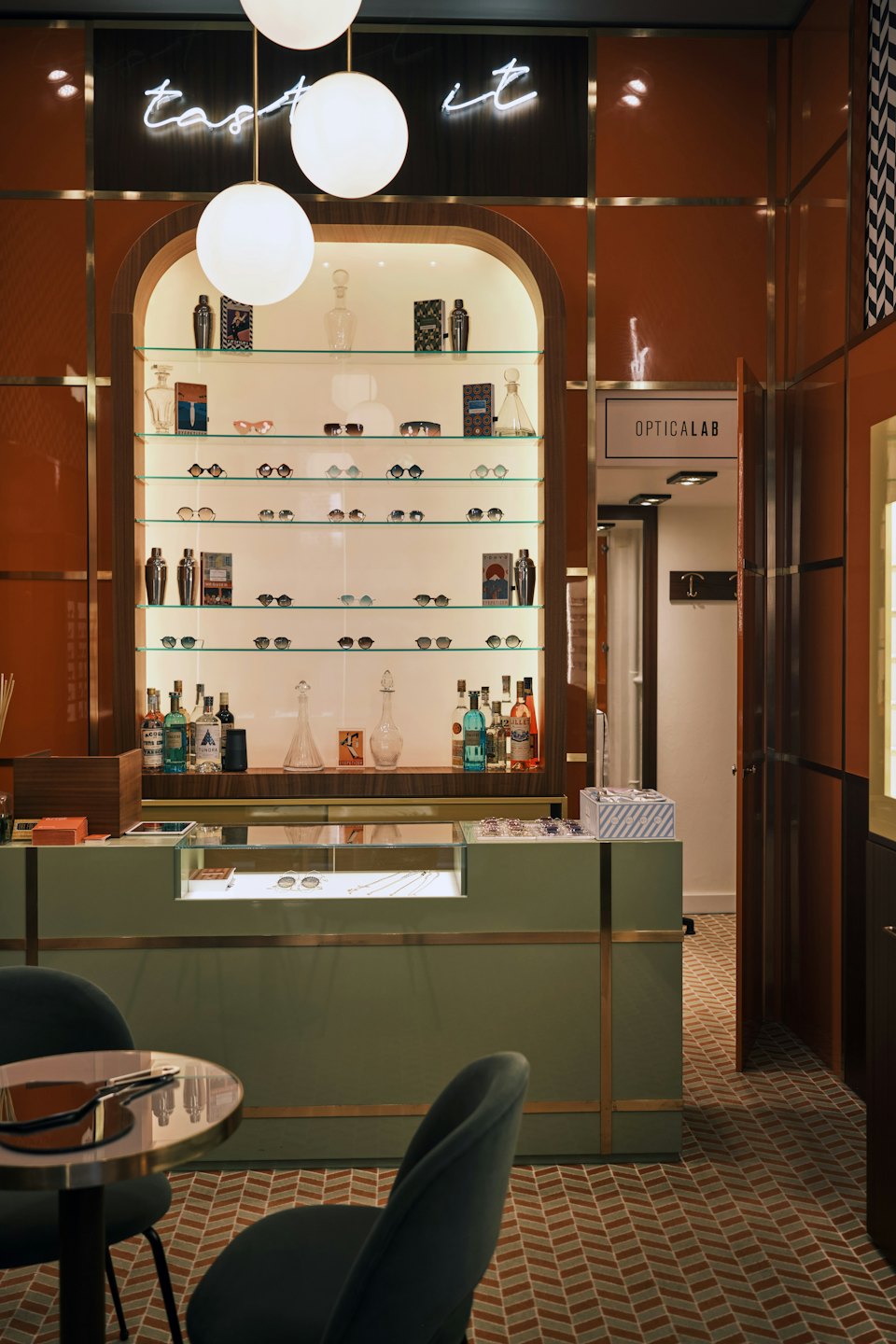 Interno di una boutique ottica con scaffali di occhiali e luci a sospensione.